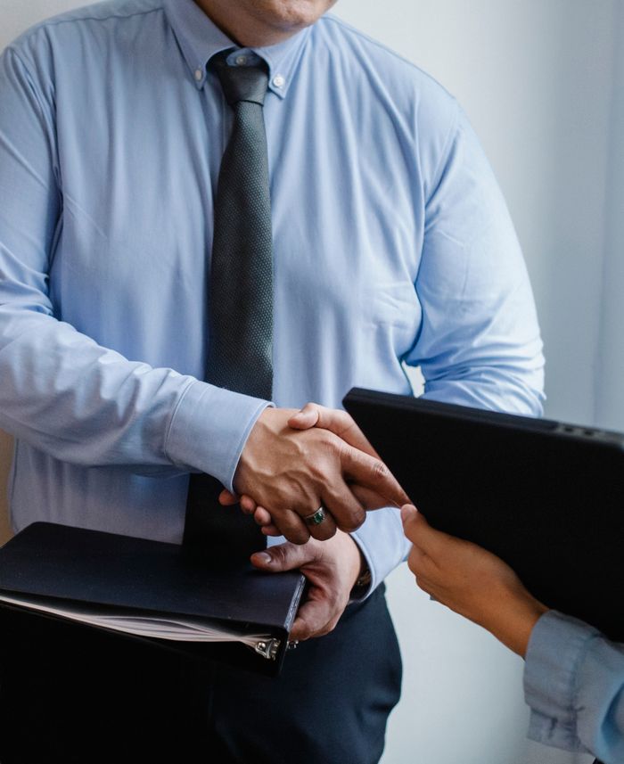 The Art of Drawing Readers In: Your attractive post title goes here Faceless coworkers in formal clothes shaking hands during meeting at work in light office